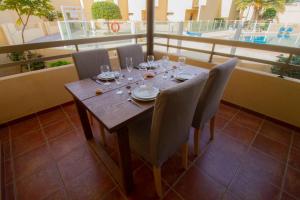 La TejitaにあるMEDANO4YOU Casa Magic 3の木製テーブル(椅子付)、バルコニー(ワイングラス付)