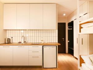 a kitchen with white cabinets and a sink at VISTA Gudauri - White decision in Gudauri