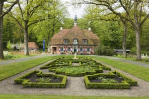 Una casa grande con un jardín enfrente. en Sfeervol 6 persoons appartement - van alle gemakken voorzien!, en Bakkeveen