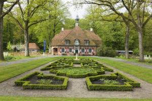 a large house with a garden in front of it at Sfeervol 6 persoons appartement - van alle gemakken voorzien! in Bakkeveen