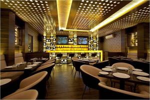 a dining room with tables and chairs and lights at Hotel Plaza in Mumbai