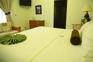 een slaapkamer met een groot wit bed met een plant erop bij Villa Bonita Les Terrasses in Cuernavaca