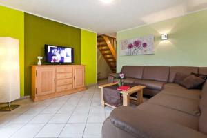 a living room with a couch and a tv at Ferienwohnung mit Balkon im Ostsee in Binz +33 photos