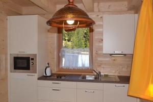 cocina con fregadero y ventana en Talhütte App.2, en Hinteralm