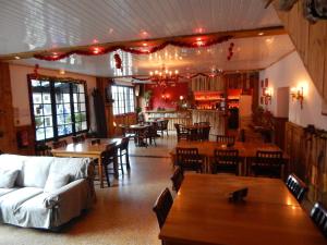 a restaurant with tables and chairs and a couch at Pyrenées Emotions in Malvézie