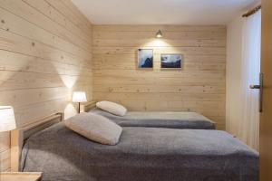 ザコパネにあるApartament Antałówka z ogródkiemの木製の壁の客室で、ツインベッド2台が備わります。