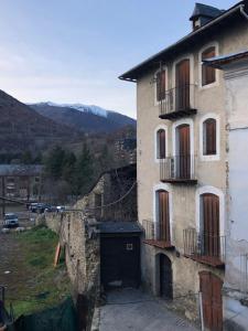 an old building with a door and a balcony at Casa Serraller in Esterri d'Àneu