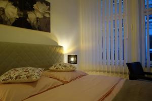 1 dormitorio con 1 cama con 2 almohadas y lámpara en Nettes, gemütliches Apartment en Wuppertal