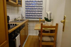 una pequeña cocina con una mesa pequeña y un fregadero en Nettes, gemütliches Apartment en Wuppertal