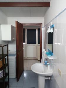 a bathroom with a white sink and a toilet at Suite Marina in Trapani