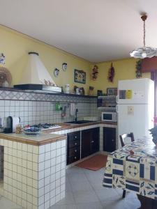 a kitchen with a white refrigerator and a table at Suite Marina in Trapani