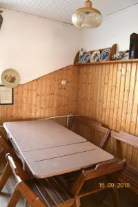un tavolo in una stanza con una parete in legno di Bylinka a Trzcińsko Zdrój