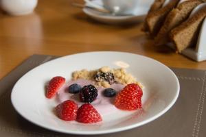 a plate of fruit with yogurt and berries on a table at The Boat and Breakfast in Inverness