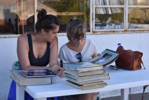 dos mujeres sentadas en una mesa con libros en Rooms São Dinis, en Oporto