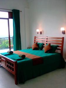 a bedroom with a large bed with a large window at HIDE IN HANTANA The best place to hide in Kandy in Kandy