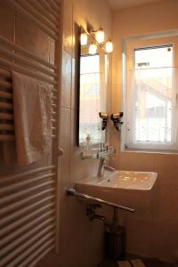 a bathroom with a sink and a mirror and a window at Ferienhaus Gundi in Pettneu am Arlberg