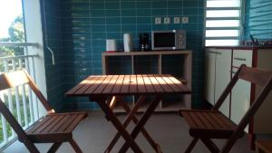 a kitchen with a wooden table and two chairs at Gites Man-non in Sainte-Anne