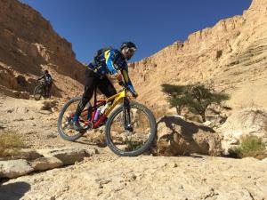 um homem a andar de bicicleta no deserto em Elifaz Desert Experience Holiday em Elifaz