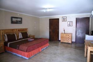 A bed or beds in a room at Palmeiras Guest House Matola