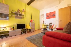 a living room with a red couch and yellow walls at Arpa Apartments Bologna Center in Bologna