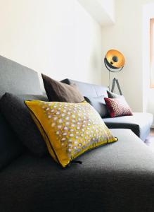 almohada amarilla en el sofá de la sala de estar en Ferienwohnung am Franziskaner Tor en Überlingen