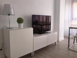 una sala de estar con TV en un armario blanco en Un Lujo en el Corazón de Alicante, en Alicante