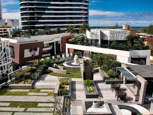 a building with a courtyard with benches and tables at Luxury 3 Bedroom in heart of Broadbeach in Gold Coast