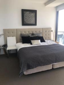 a bedroom with a large bed and a chair at Luxury 3 Bedroom in heart of Broadbeach in Gold Coast