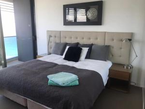 a bedroom with a large bed with a blue towel on it at Luxury 3 Bedroom in heart of Broadbeach in Gold Coast +15 photos