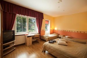 ein Hotelzimmer mit 2 Betten und einem TV in der Unterkunft Alexi Villa in Tallinn