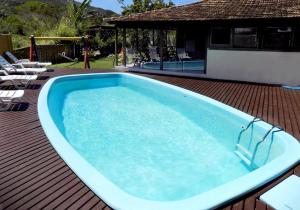 una gran piscina en la parte superior de una terraza de madera en Pousada A Cabana, en Garopaba