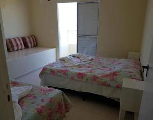 1 dormitorio con 2 camas y ventana en Peruíbe Frente ao Mar - Aptos, en Peruíbe