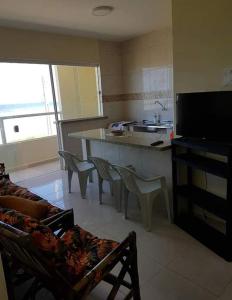 sala de estar con cocina con mesa y sillas en Peruíbe Frente ao Mar - Aptos, en Peruíbe
