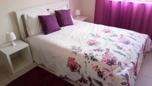ペニシェにあるPeniche holiday homeのベッドルーム(紫色の枕が付いた白いベッド付)