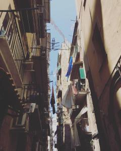 Une ruelle étroite avec des bâtiments et un ciel bleu dans l'établissement Giù al Centro, à Naples