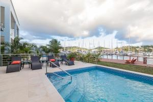 a swimming pool with patio furniture and a marina at Waters Edge Villas by Bay Gardens Resorts in Gros Islet
