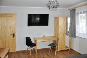 Televízia a/alebo spoločenská miestnosť v ubytovaní Apartamenty JSZI