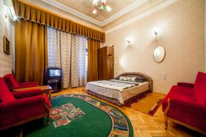 キーウにあるApartments near Khreshchatyk-Absolutのベッドルーム1室(ベッド1台、椅子2脚、テレビ付)