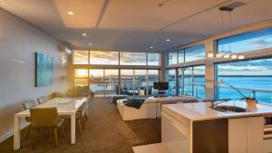 a kitchen and living room with a view of the ocean at Princes Wharf's truly stunning North-West Loft in Auckland