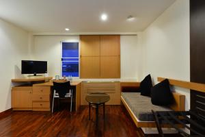 a living room with a couch and a desk with a television at iCheck inn Sukhumvit 19 in Bangkok +30 photos
