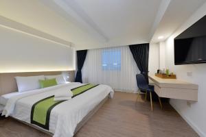 a bedroom with a bed and a desk and a television at iCheck inn Sukhumvit 19 in Bangkok