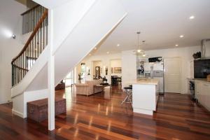 an open living room and kitchen with a staircase at Mudgee Country Grandeur at this Elegant Group Getaway in Mudgee