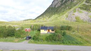 uma pequena casa ao lado de uma montanha em Lofoten - Høynes em Bøstad