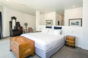 a bedroom with a large white bed and a dresser at Mudgee Country Grandeur at this Elegant Group Getaway in Mudgee +38 photos
