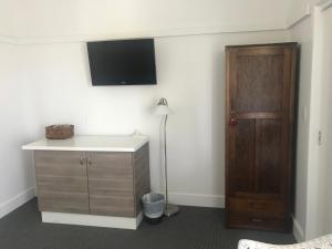 a room with a dresser and a tv on the wall at Marlo Hotel in Marlo
