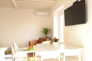 - une salle à manger blanche avec une table et des chaises blanches dans l'établissement Ocean View Penthouse, à Paço de Arcos