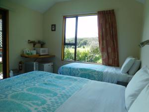two beds in a room with a large window at Mountainview Makarora Accommodation in Makarora