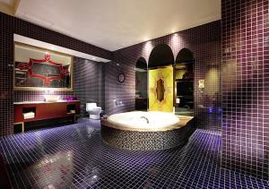Royal Group Motel Wu Yin Branch في كاوشيونغ: حمام كبير مع حوض استحمام ومرحاض