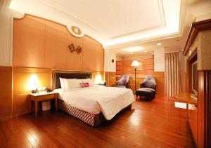 Habitación de hotel con 1 cama y 2 sillas en Royal Group Motel Tainan Branch, en Tainan