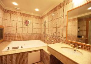 a bathroom with a tub and a large mirror at Royal Group Motel Tainan Branch in Tainan